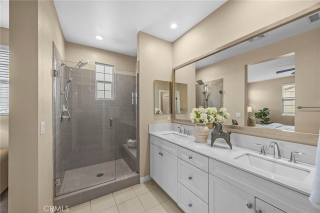 ensuite bathroom with double vanity, tile patterned flooring, a shower stall, and a sink