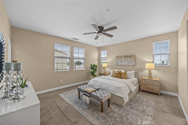 bedroom with light carpet, baseboards, a ceiling fan, and visible vents