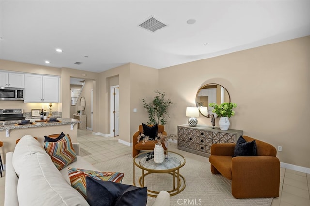 living area with light tile patterned floors, recessed lighting, baseboards, and visible vents