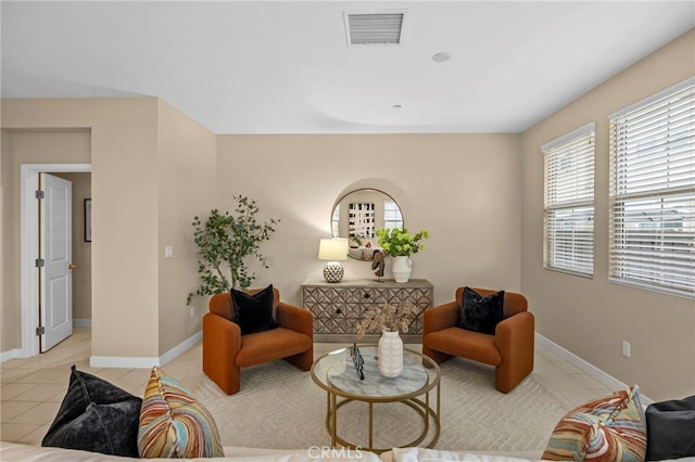living area with baseboards, light tile patterned floors, and visible vents