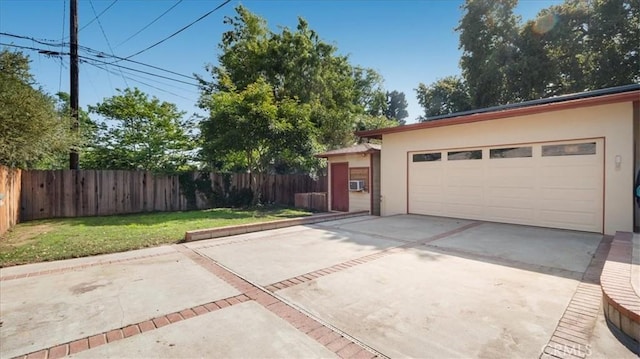 garage featuring driveway and fence