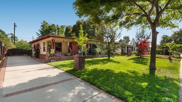 ranch-style home with a front lawn and fence