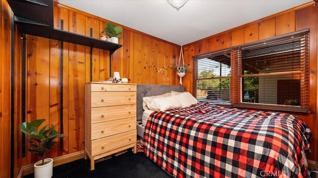 carpeted bedroom featuring wooden walls