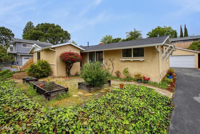 ranch-style home with a vegetable garden, stucco siding, and a garage