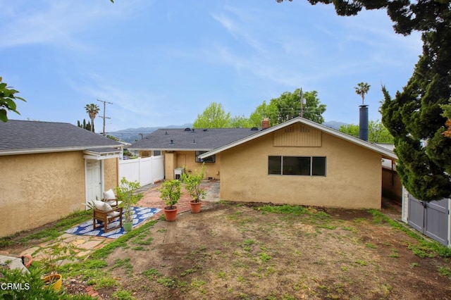 back of property featuring fence, a patio, and stucco siding