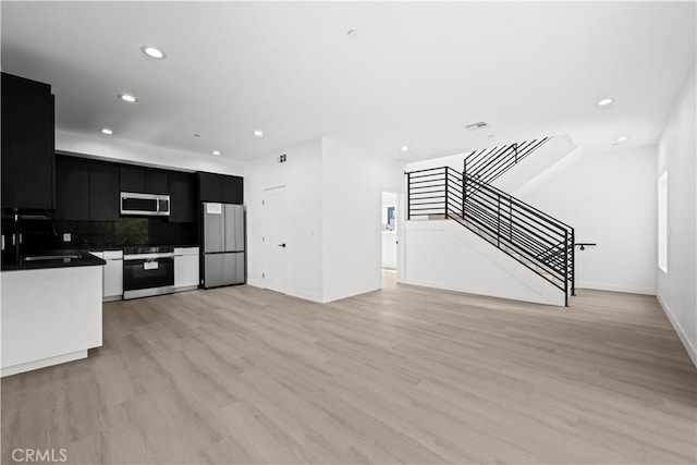 648 N Boyle Ave, Los Angeles, CA 90033 - kitchen featuring light wood-style flooring, recessed lighting, dark cabinetry, a sink, and stainless steel appliances