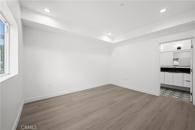 648 N Boyle Ave, Los Angeles, CA 90033 - interior space featuring baseboards, light wood-style flooring, recessed lighting, and a tray ceiling