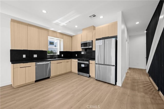 648 N Boyle Ave, Los Angeles, CA 90033 - kitchen featuring light brown cabinets, visible vents, dark countertops, stainless steel appliances, and tasteful backsplash