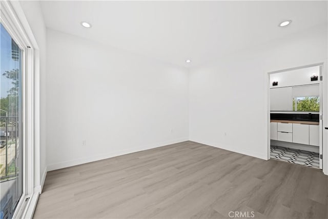 648 N Boyle Ave, Los Angeles, CA 90033 - unfurnished living room with light wood-style flooring, baseboards, and recessed lighting