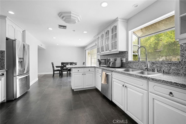 7980 Hollywood Way, Sun Valley, CA 91352 - kitchen featuring a sink, a peninsula, stainless steel appliances, visible vents, and backsplash