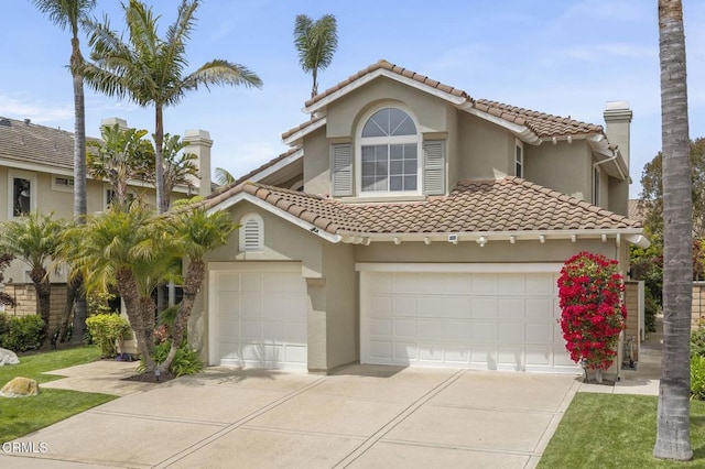 2113 Doral Ct, Oxnard, CA 93036 - mediterranean / spanish-style house featuring a tile roof, concrete driveway, a garage, stucco siding, and a chimney
