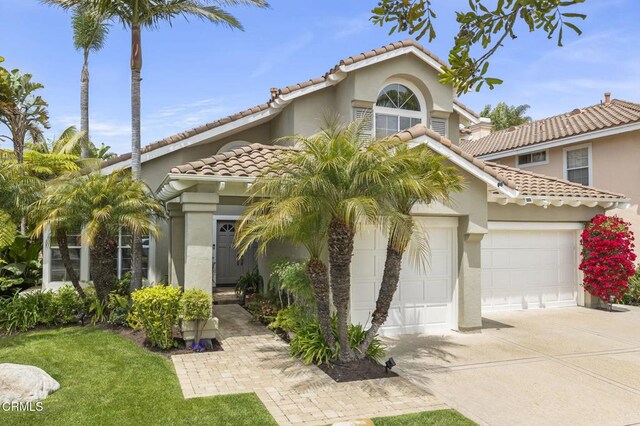 2113 Doral Ct, Oxnard, CA 93036 - mediterranean / spanish house featuring a tile roof, concrete driveway, stucco siding, and a front lawn