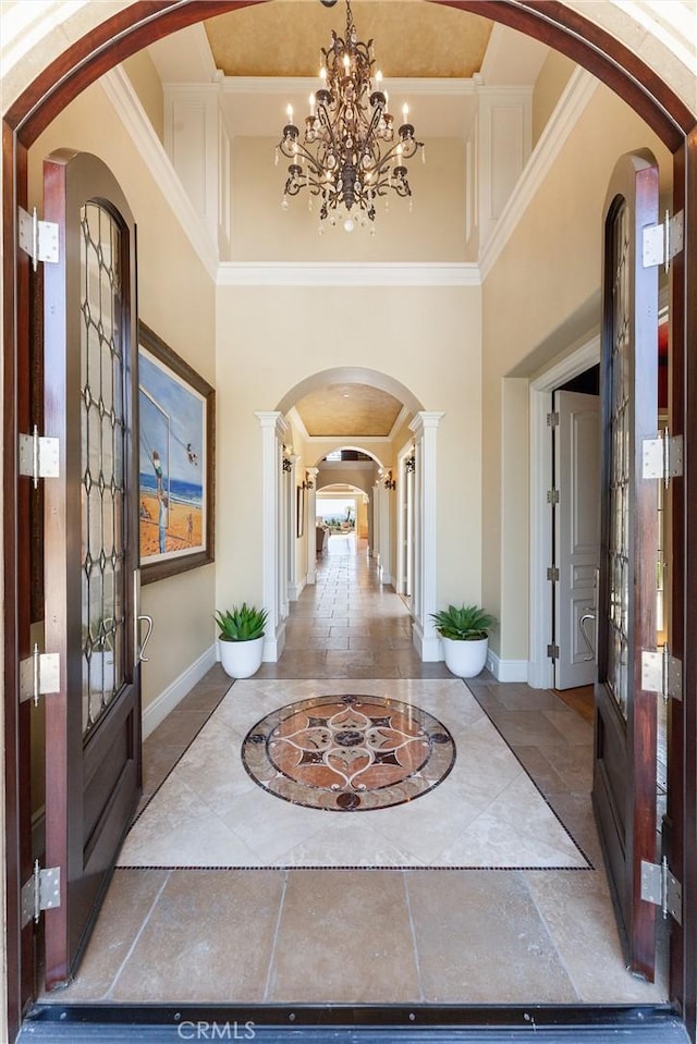 19 Fox Hole Rd, Ladera Ranch, CA 92694 - foyer featuring inlaid floor details, arched walkways, a towering ceiling, a chandelier, and crown molding