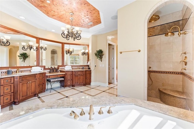 full bathroom featuring a tile shower, a tray ceiling, a chandelier, vanity, and recessed lighting
