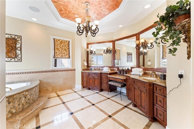 full bathroom with a chandelier, a raised ceiling, and vanity