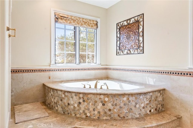 full bathroom featuring tile walls, tile patterned flooring, a garden tub, and a wainscoted wall