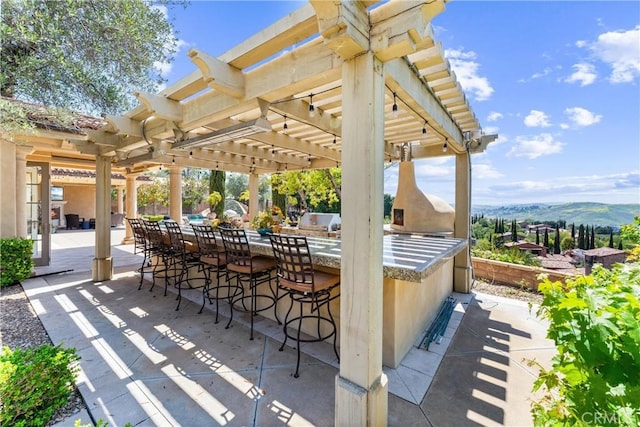 view of patio / terrace featuring a pergola, a mountain view, and outdoor dry bar