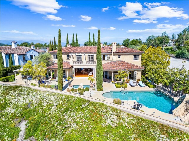 19 Fox Hole Rd, Ladera Ranch, CA 92694 - back of property featuring a tile roof, a patio area, stucco siding, a balcony, and a chimney