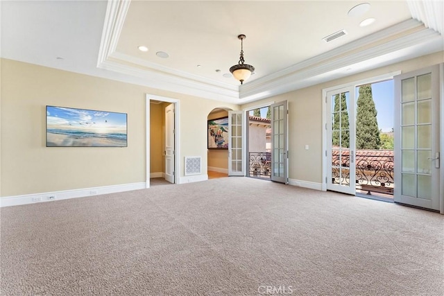 spare room featuring a tray ceiling, ornamental molding, french doors, and visible vents