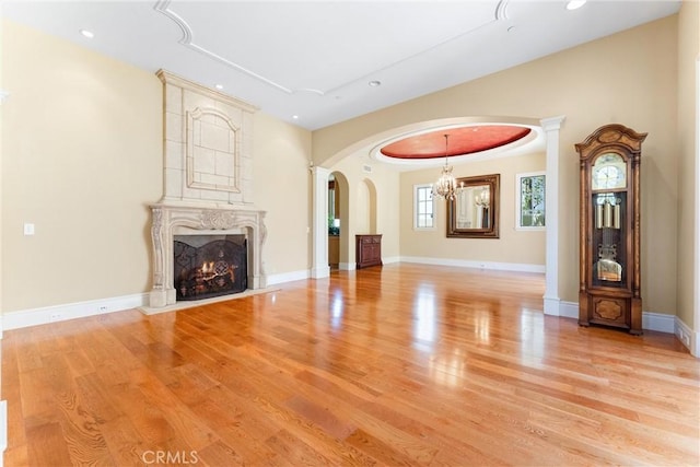 19 Fox Hole Rd, Ladera Ranch, CA 92694 - unfurnished living room featuring arched walkways, a chandelier, light wood-style floors, a high end fireplace, and recessed lighting