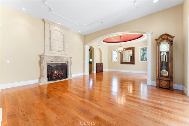 19 Fox Hole Rd, Ladera Ranch, CA 92694 - unfurnished living room with arched walkways, a chandelier, light wood finished floors, a premium fireplace, and recessed lighting