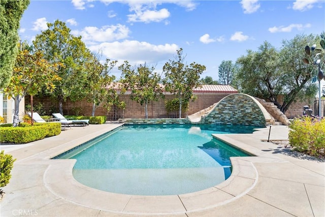 view of swimming pool featuring fence, a water slide, a patio area, and a fenced in pool