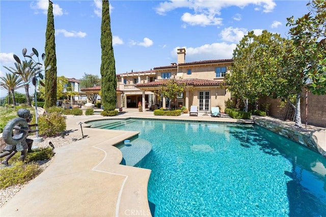 outdoor pool with a patio and french doors