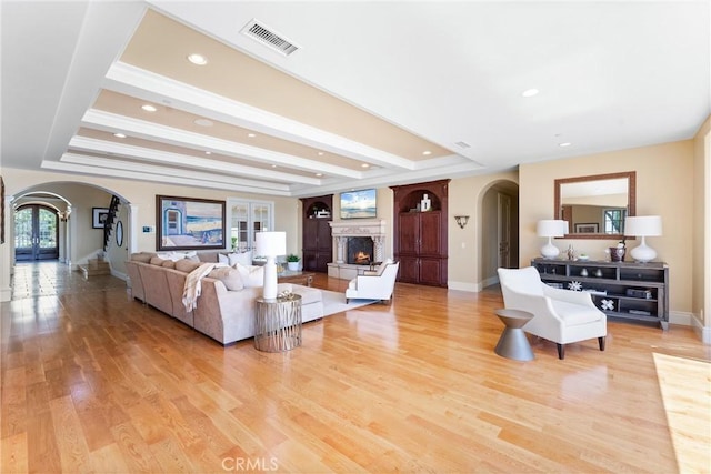 19 Fox Hole Rd, Ladera Ranch, CA 92694 - living area with arched walkways, a lit fireplace, light wood-style floors, recessed lighting, and beamed ceiling