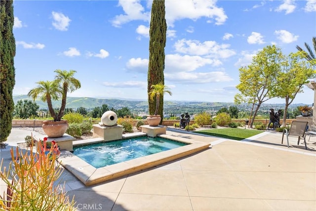 view of pool with a hot tub, a patio, and a mountain view