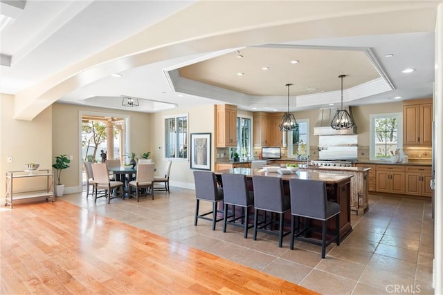 19 Fox Hole Rd, Ladera Ranch, CA 92694 - kitchen featuring a tray ceiling, a large island, a breakfast bar, arched walkways, and healthy amount of natural light