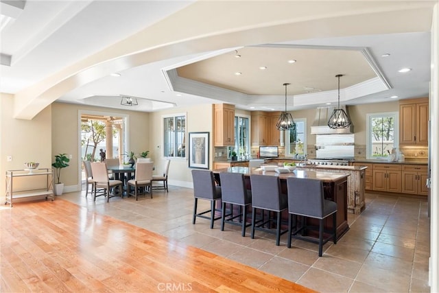 19 Fox Hole Rd, Ladera Ranch, CA 92694 - kitchen with a tray ceiling, a spacious island, a breakfast bar area, arched walkways, and healthy amount of natural light
