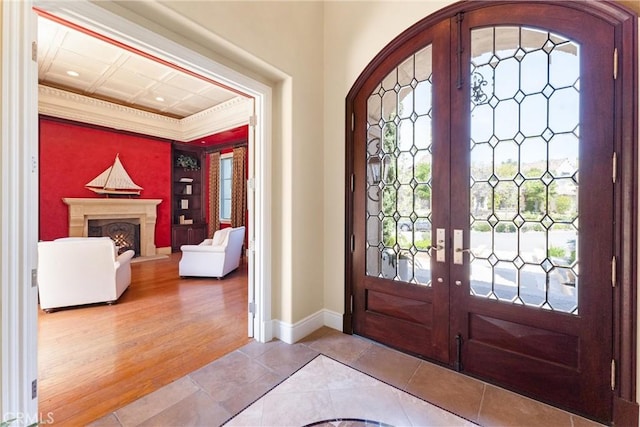 entrance foyer with tile patterned flooring, french doors, baseboards, and ornamental molding