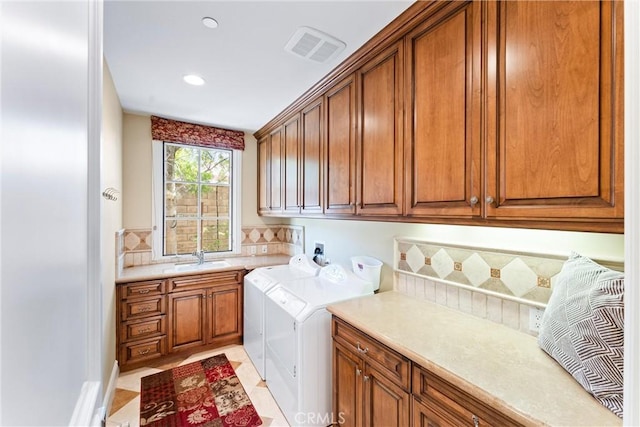 washroom with recessed lighting, washer and dryer, visible vents, a sink, and cabinet space