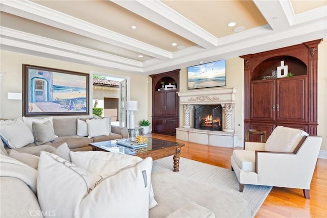living room featuring a premium fireplace, ornamental molding, light wood finished floors, and recessed lighting