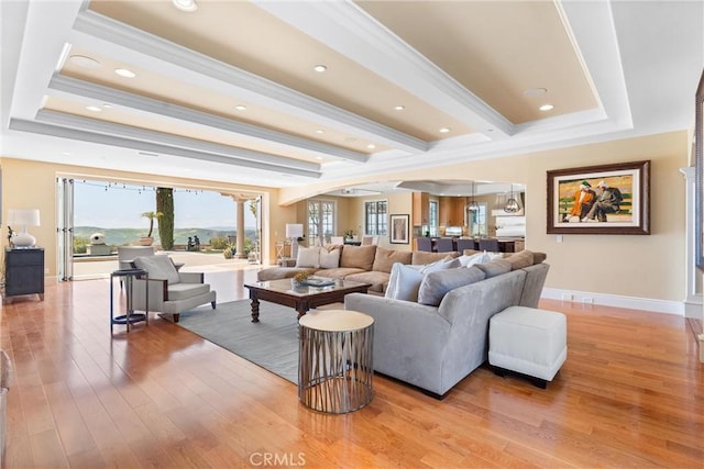 living room featuring ornamental molding, light wood-style flooring, baseboards, and recessed lighting