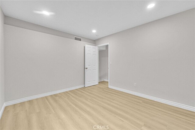 unfurnished room featuring baseboards, light wood finished floors, and recessed lighting