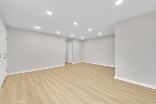 unfurnished room featuring recessed lighting, light wood-style floors, and baseboards