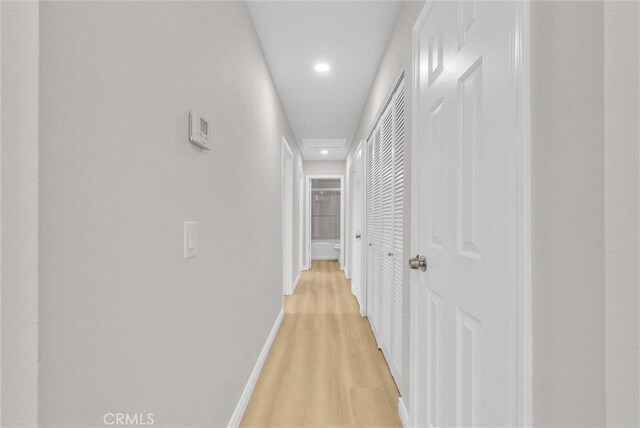corridor with recessed lighting, light wood-type flooring, and baseboards