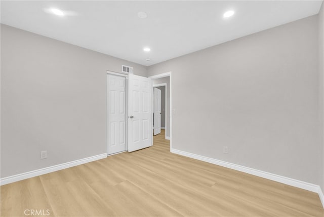 unfurnished bedroom featuring baseboards, light wood-style floors, recessed lighting, and a closet