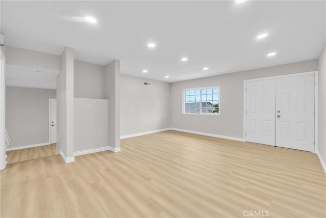 below grade area featuring light wood finished floors, recessed lighting, and baseboards