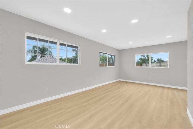 empty room featuring baseboards, light wood-style floors, and recessed lighting