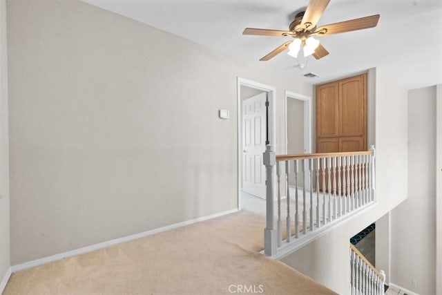 spare room with light carpet, baseboards, and ceiling fan