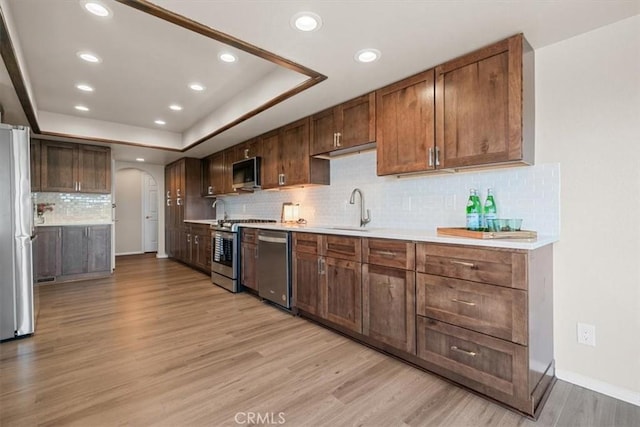 2322 Almond Springs Dr, Paso Robles, CA 93446 - kitchen with appliances with stainless steel finishes, a sink, recessed lighting, light wood-style floors, and arched walkways