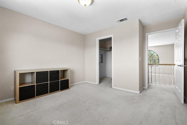 unfurnished bedroom with carpet floors, baseboards, and a spacious closet