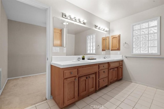 bathroom featuring double vanity, baseboards, and tile patterned flooring