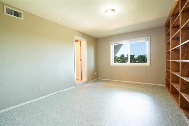 carpeted spare room featuring baseboards