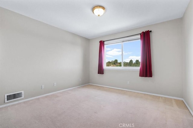 spare room featuring carpet floors and baseboards