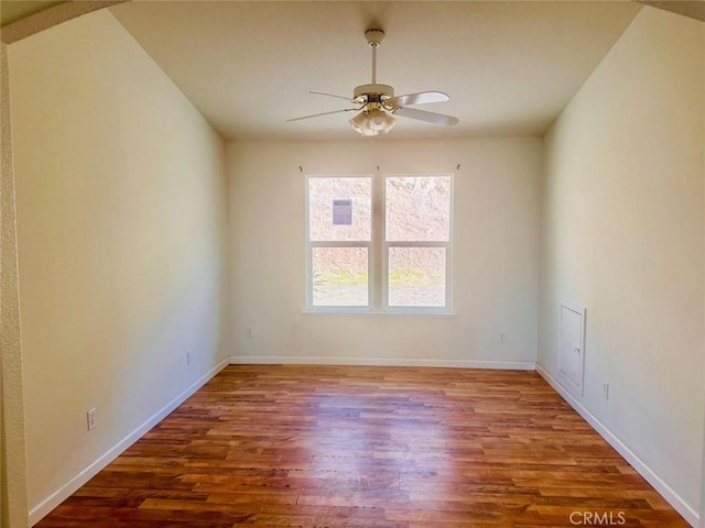 unfurnished room with baseboards, wood finished floors, and a ceiling fan