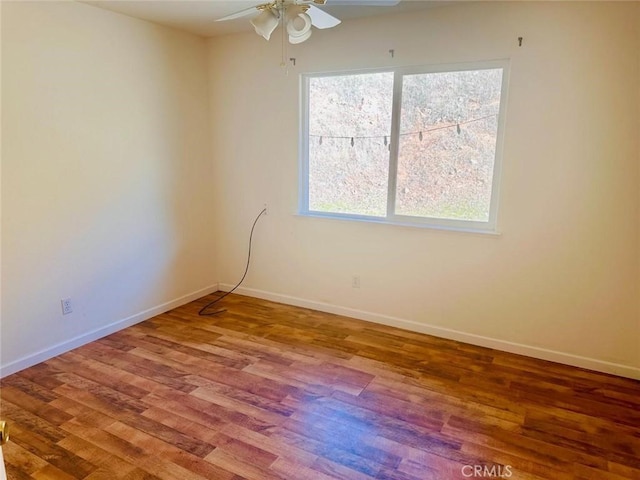 unfurnished room with baseboards, a ceiling fan, and wood finished floors