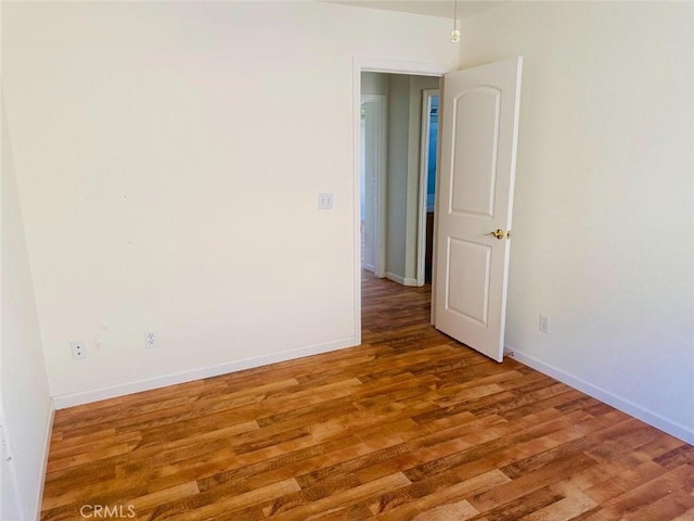 empty room with baseboards and wood finished floors